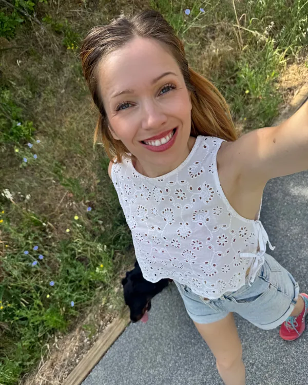 Selfie de Marie-Ange en haut blanc brodé, sur un chemin